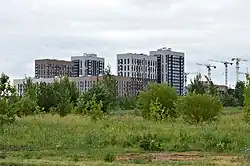 Территория будущей застройки микрорайона 4 на фоне строящегося жилого комплекса «Мой Ритм» (июль 2021)
