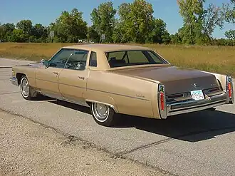 1976 Cadillac Sedan Deville, хромированные окантовки стоп-сигналов, хорошо видны сминаемые вставки между задними крыльями и фонарями