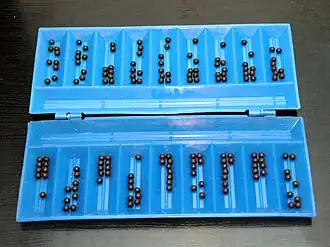 Складная пластмассовая доска (казахский вариант без различения сторон по цветам) для игры в тогуз коргоол. Начальная позиция. В каждой лунке по 9 шариков.